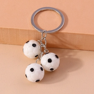 Detailed close-up of a silver key ring with three realistic 3D soccer ball pendants