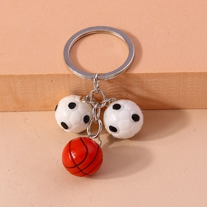 Detailed macro view of 3D football and basketball pendants on a metal keychain ring