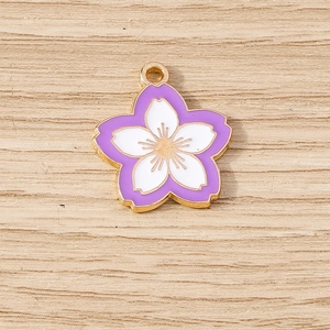Macro view of cherry blossom pendant with purple enamel and gold plating detail