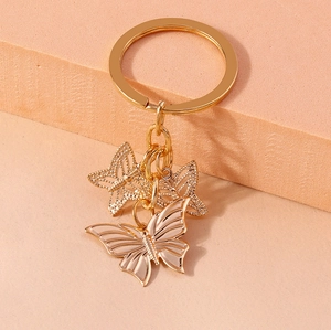 Detailed macro view of rose gold alloy butterfly keychains with hollow textured pendants
