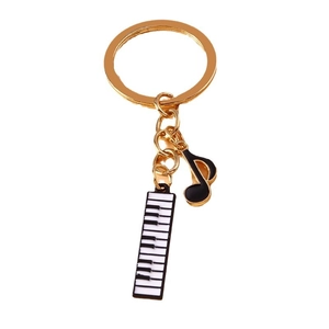 Golden music theme keychain with piano keyboard and black eighth note charms on white background