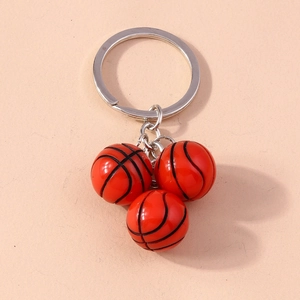 Detailed close-up of three orange basketball keychains with metallic ring and black lines