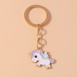 Detail of cartoon unicorn keychain featuring white enamel body with purple hair and gold metal