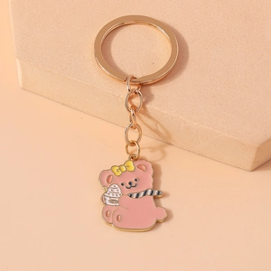 Detail of pink cartoon bear keychain with ice cream cup and gold metal ring