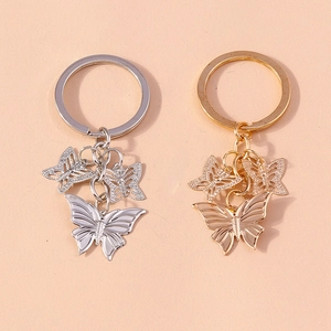 Symmetric display of gold and silver alloy butterfly keychains with hollow pendants