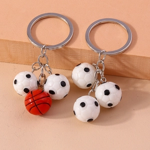 3D soccer and basketball keychain set with silver metal rings on a textured background