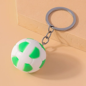 Detailed view of the green and white soccer keychain with silver metal chain on beige prop