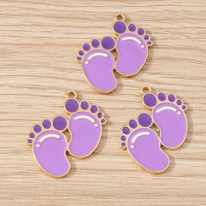 Detailed macro view of purple enamel baby footprint pendants with golden zinc alloy edges