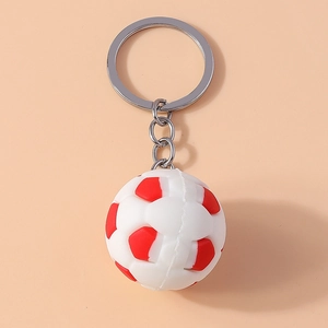Close-up of a red and white 3D soccer ball keychain with silver metal ring and chain