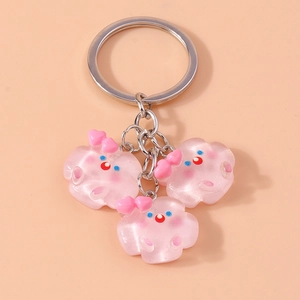 Vue détaillée de porte-clés pailletés rose avec anneau métallique sur fond orange