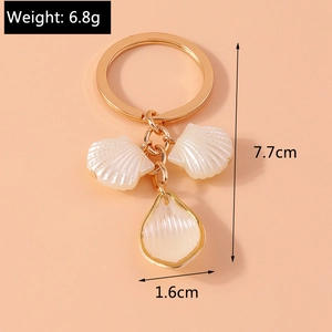 Detail view of pearl shell charms on gold keychain with 7.7cm length measurement