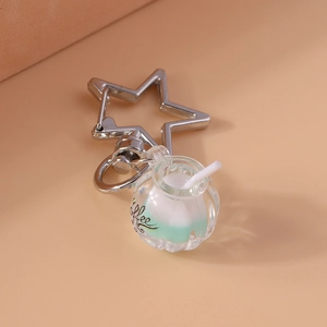 Detailed close-up of a creative luminous coffee cup keychain with star-shaped silver clasp