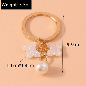 Detailed view showing the golden butterfly charms and pearl pendant with measurements