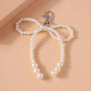 Elegant white pearl bow keychain with gradient bead design and silver lobster clasp