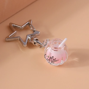 Close-up of a creative coffee cup keychain with star-shaped clasp and pink liquid