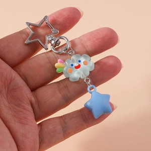 Détail d'un anneau porte-clés en forme d'étoile avec nuage souriant et pendentif bleu