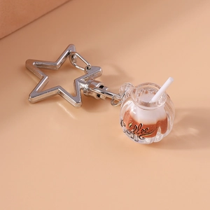 Detailed macro view of creative star-shaped metal ring and miniature coffee cup keychain