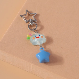 Détail d'un porte-clés nuage mignon avec queue arc-en-ciel et pendentif étoile bleue
