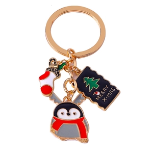Christmas keychain with gold ring featuring a stocking, penguin, and Merry X-MAS pendant