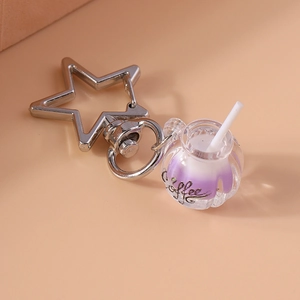 Macro shot of a creative luminous coffee cup keychain with a silver star-shaped carabiner clasp