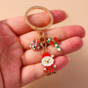 Detailed view of Santa, gift box and candy cane charms on a gold alloy keychain