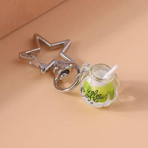 Close-up of a luminous mini coffee cup keychain with a silver star-shaped clasp