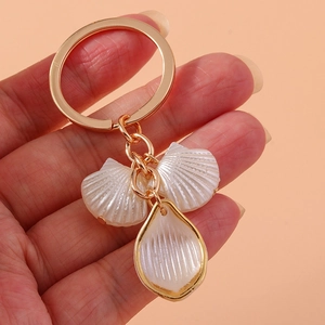 Handheld gold keychain with shell pendants featuring soft mother-of-pearl luster finish