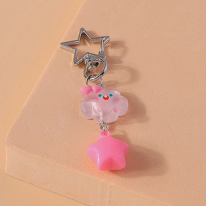 Détail du porte-clés nuage rose avec yeux bleus, bouche rouge et clip étoile
