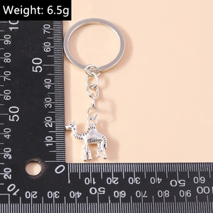 Macro detail of vintage silver camel metal keychain with textured engraving and measuring scale