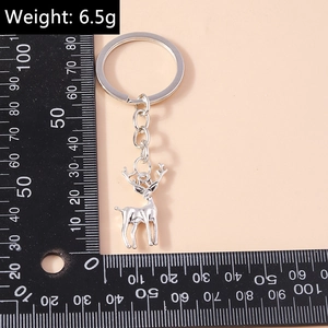 Porte-clés élan en métal argenté avec pendentif cerf poli présenté avec une règle