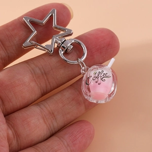 Macro shot of a creative luminous coffee cup keychain with a silver star-shaped clasp