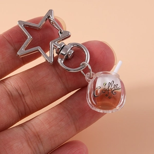 Macro shot of creative coffee cup keychain with star-shaped silver carabiner clip