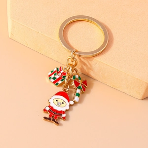 Macro view of Christmas Santa keychain with enamel gift box and candy cane pendants