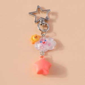 Détail du porte-clés nuage et étoile avec pendentif soleil sur fond rose doux