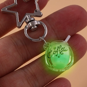 Detailed view of luminous coffee cup keychain with star-shaped silver metal hook