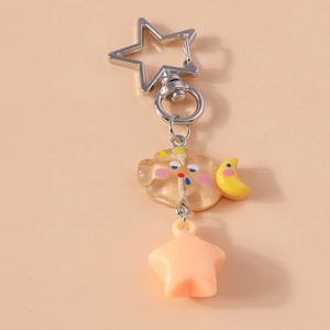 Détail de porte-clés avec breloques nuage mignon, lune jaune et étoile rose sur fond rose