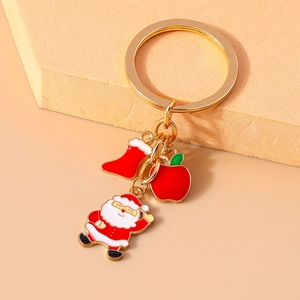 Detail of gold Santa keychain with colorful enamel charms on a simple background