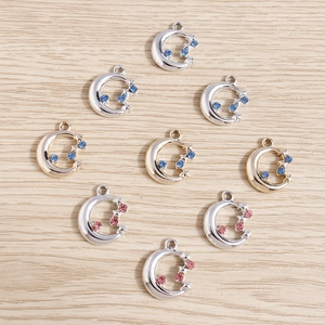 Détail de pendentifs lune et étoile avec strass colorés sur un fond en bois naturel