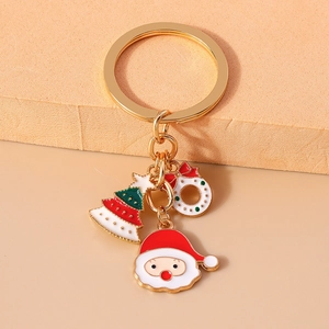 Macro shot of gold keychain with Santa Claus, Christmas tree and festive wreath charms