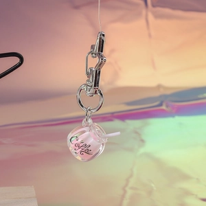 Detail of coffee cup keychain with pink liquid and star-shaped silver carabiner