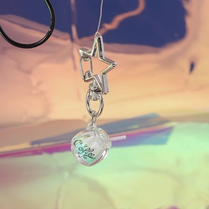 Detailed close-up of a glowing creative coffee cup keychain with a silver star-shaped clasp