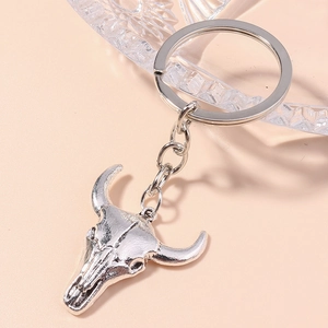Detailed close-up of a silver vintage bull skull keychain with intricate carved textures