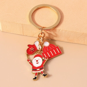 Close-up of alloy Christmas keychain with Santa, snowflake glove, and hat charms