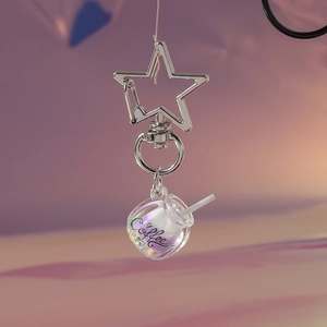 Detailed macro view of a star-shaped metal clasp and iridescent coffee cup keychain charm