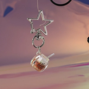 Detailed close-up of a glowing coffee cup keychain with star-shaped metal clasp