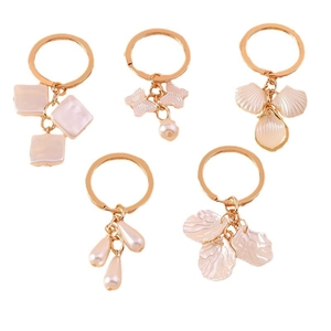 Five-piece gold keychains with butterfly and pearl pendants on a white background