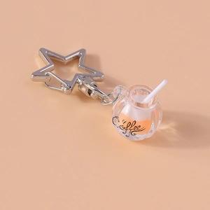 Macro view of luminous orange coffee cup keychain with silver star clip and straw detail