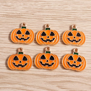 Détail de pendentifs citrouille d'Halloween en émail orange et bords dorés pour bijoux DIY