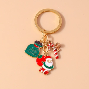 Detail of Christmas keychain with Santa, gift bag, and candy cane pendants in gold alloy