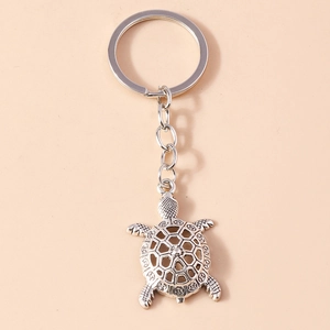 Detailed macro view of a silver sea turtle keychain with hollowed coin shell pattern